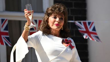 Actress Joan Collins on her balcony with a glass of champagne in London on the 75th Anniversary of VE Day, London in 2020